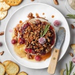 Overhead view of baked brie topped with cranberries and pecans.