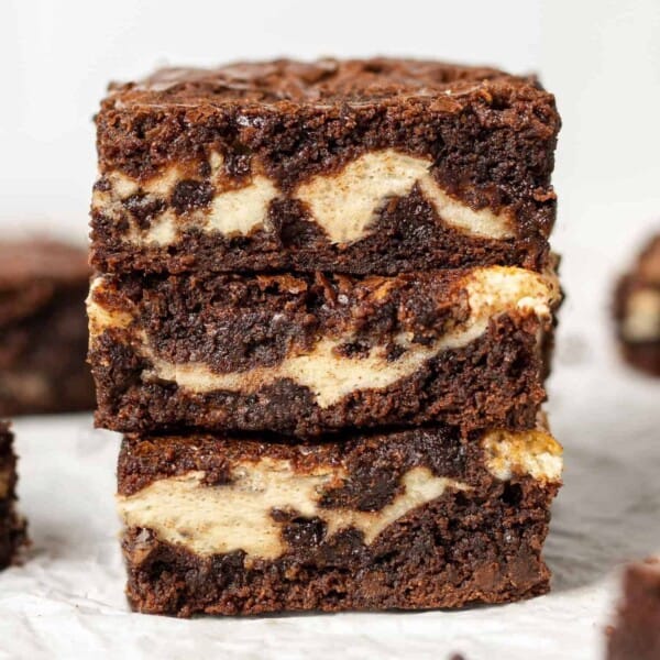 Stack of three cream cheese filled brownies.