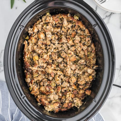 Overhead view of crockpot stuffing in black slow cooker.