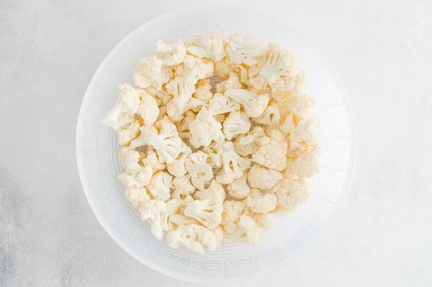 Cauliflower florets in a strainer.