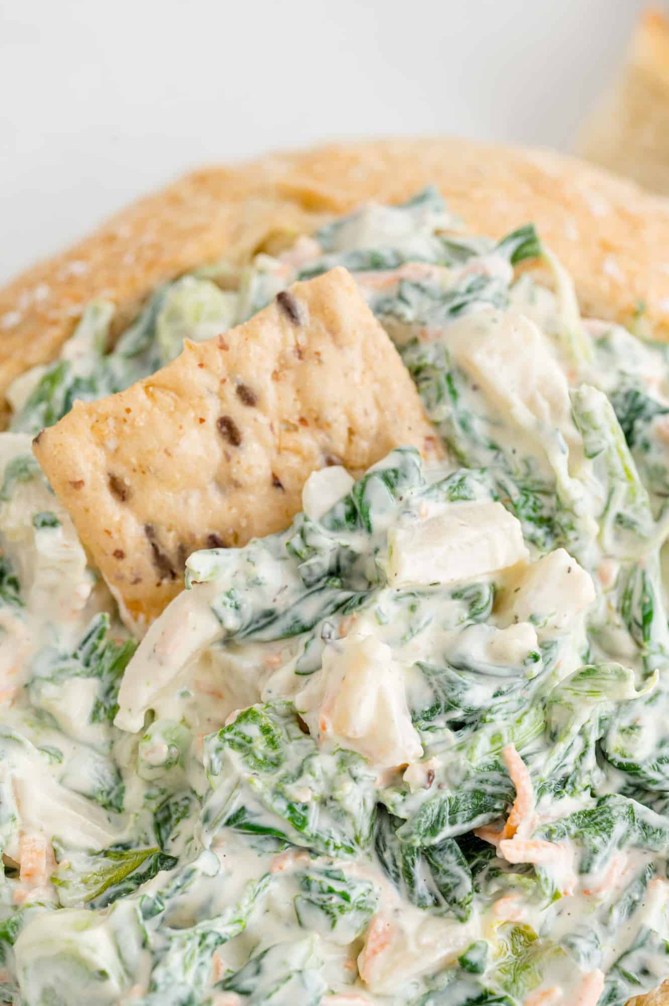 Spinach dip with a cracker in it.