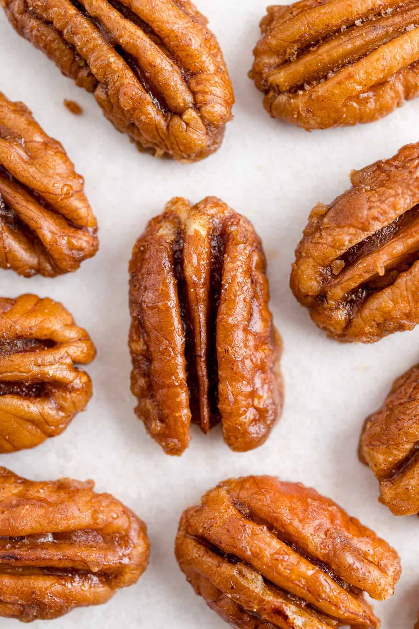 Pecans in a single layer on a white background.