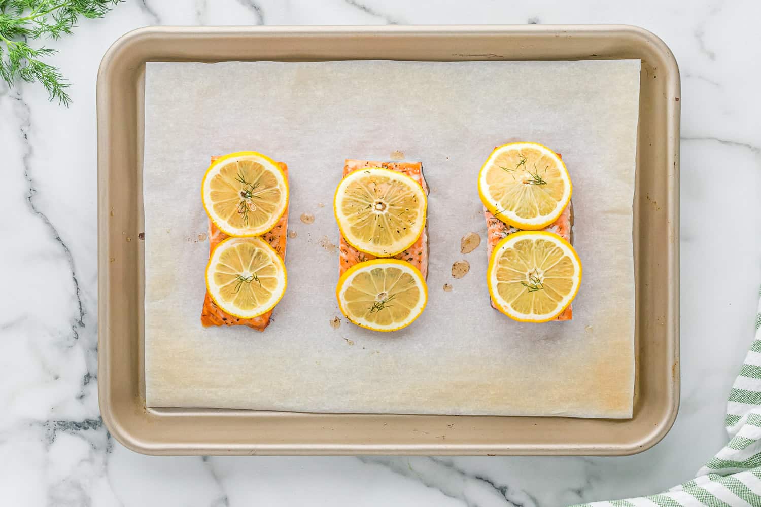 Baked salmon with lemon and dill on a sheet pan.