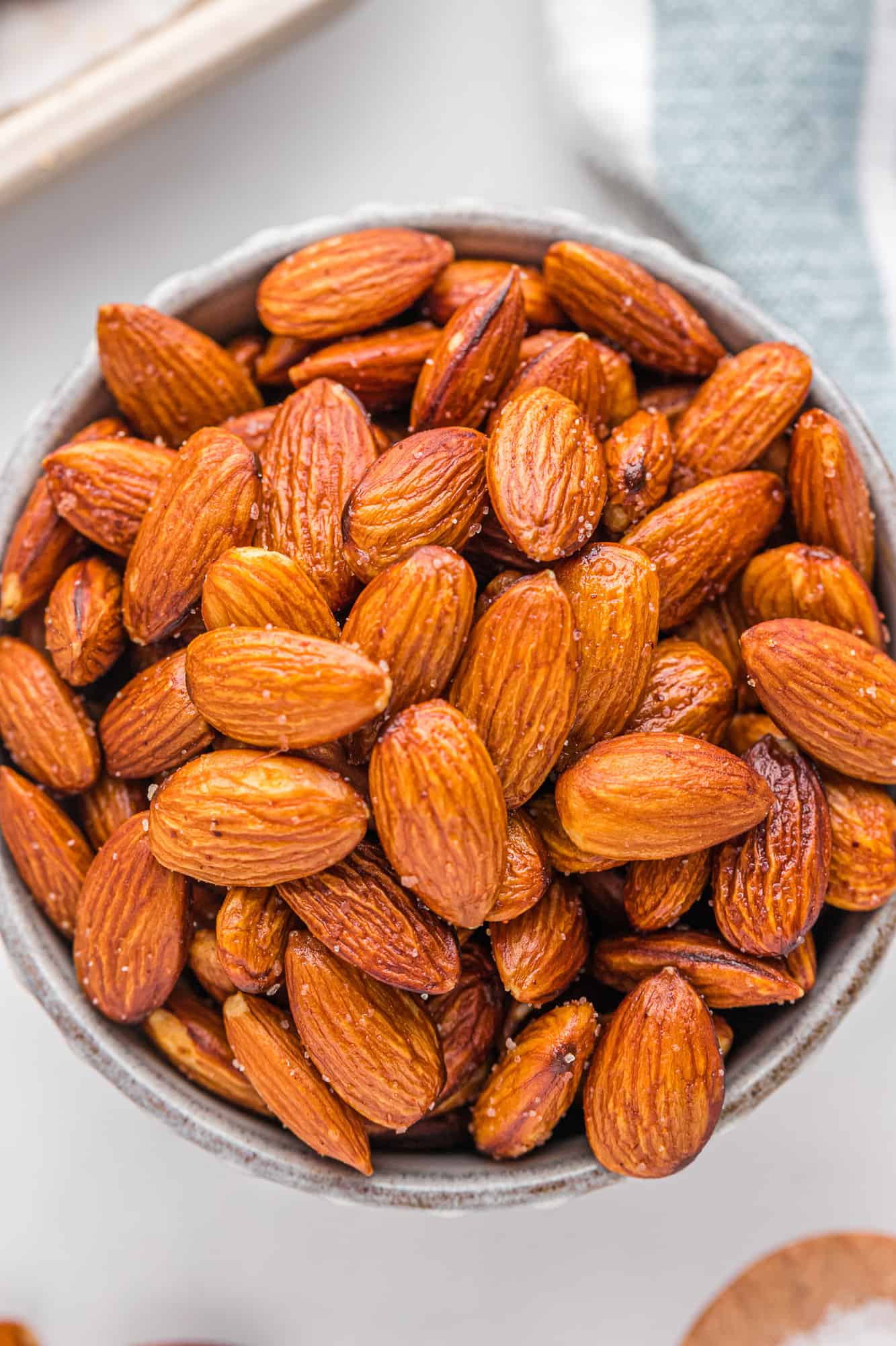 Close up of roasted almonds in a round bowl.