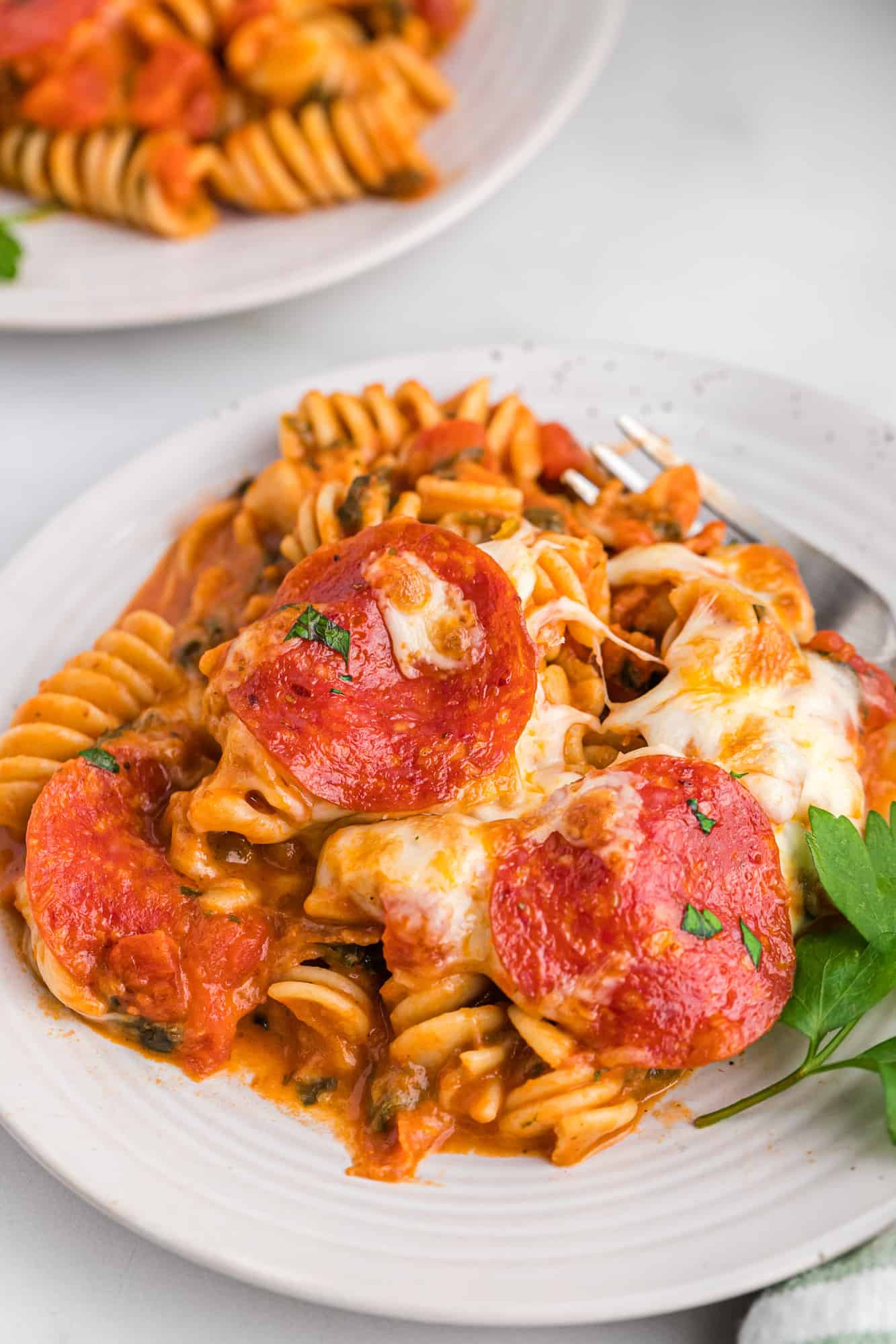 Plated pasta with cheese and pepperoni.