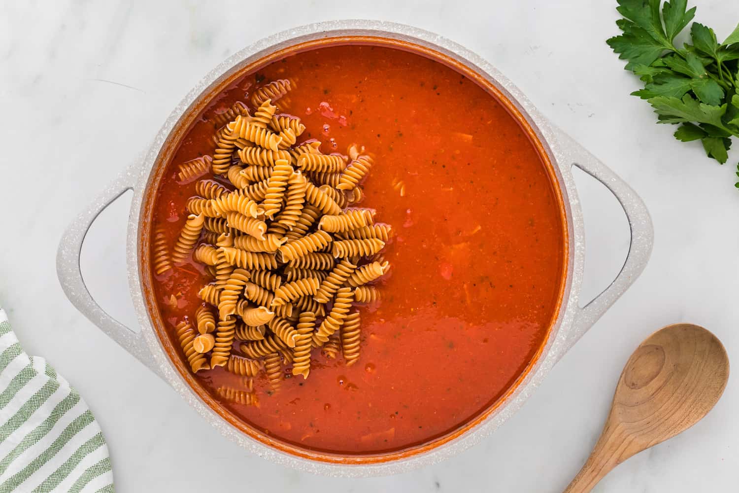 Uncooked pasta on top of tomato sauce.