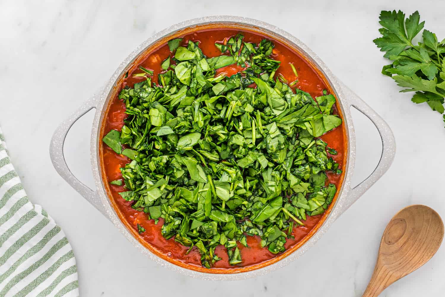 Spinach on top of pasta and sauce.