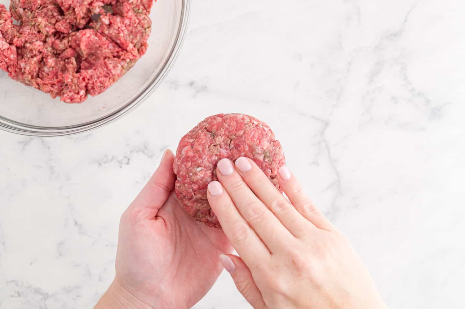 Burger being formed by hand.