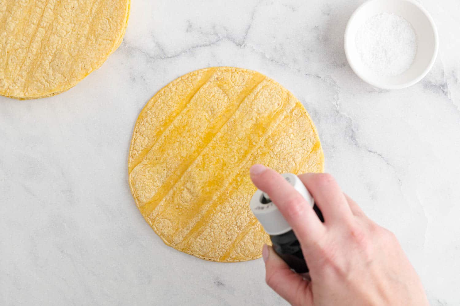 Oil being sprayed on a tortilla.