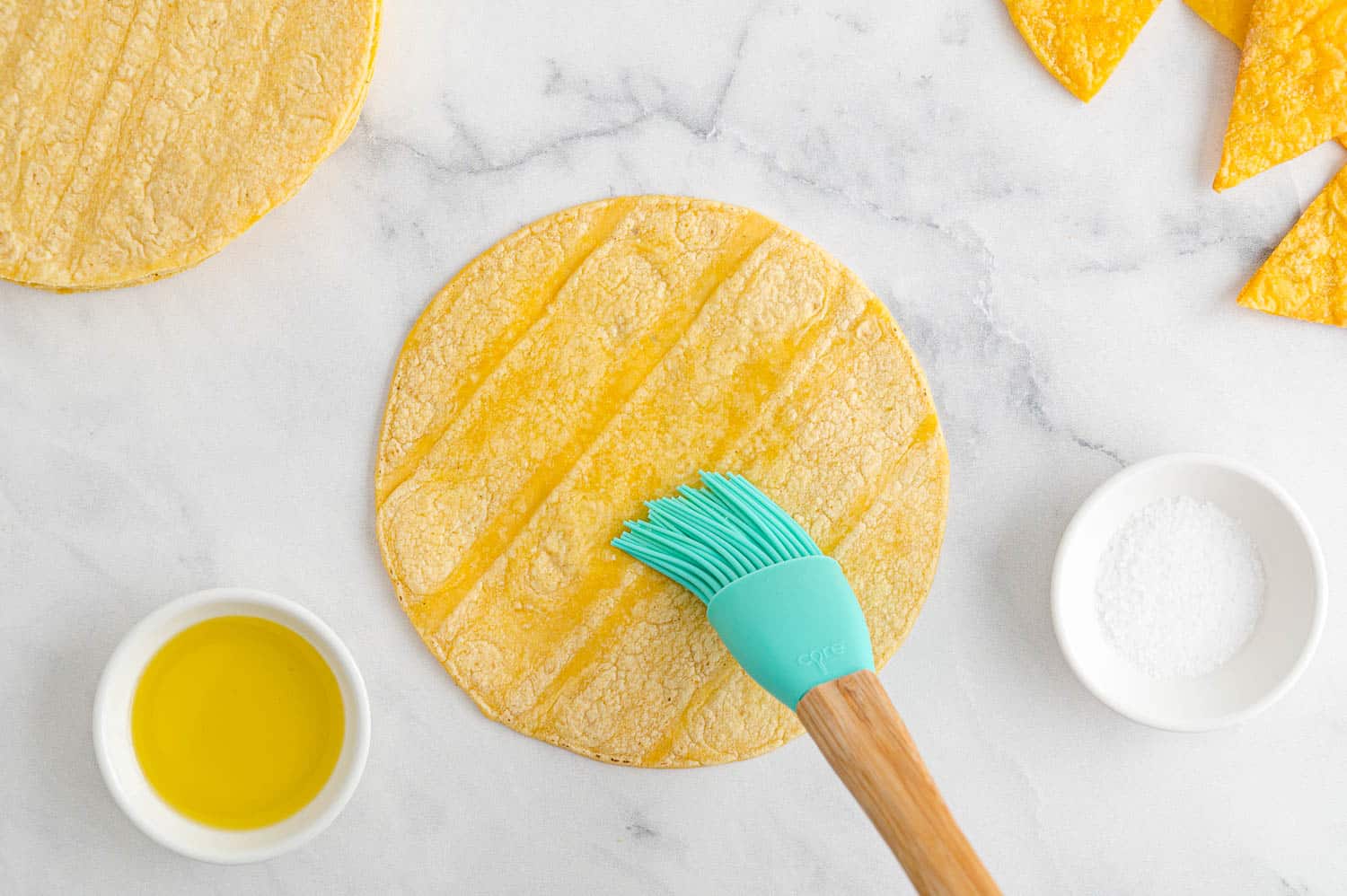 Oil being brushed on a corn tortilla.