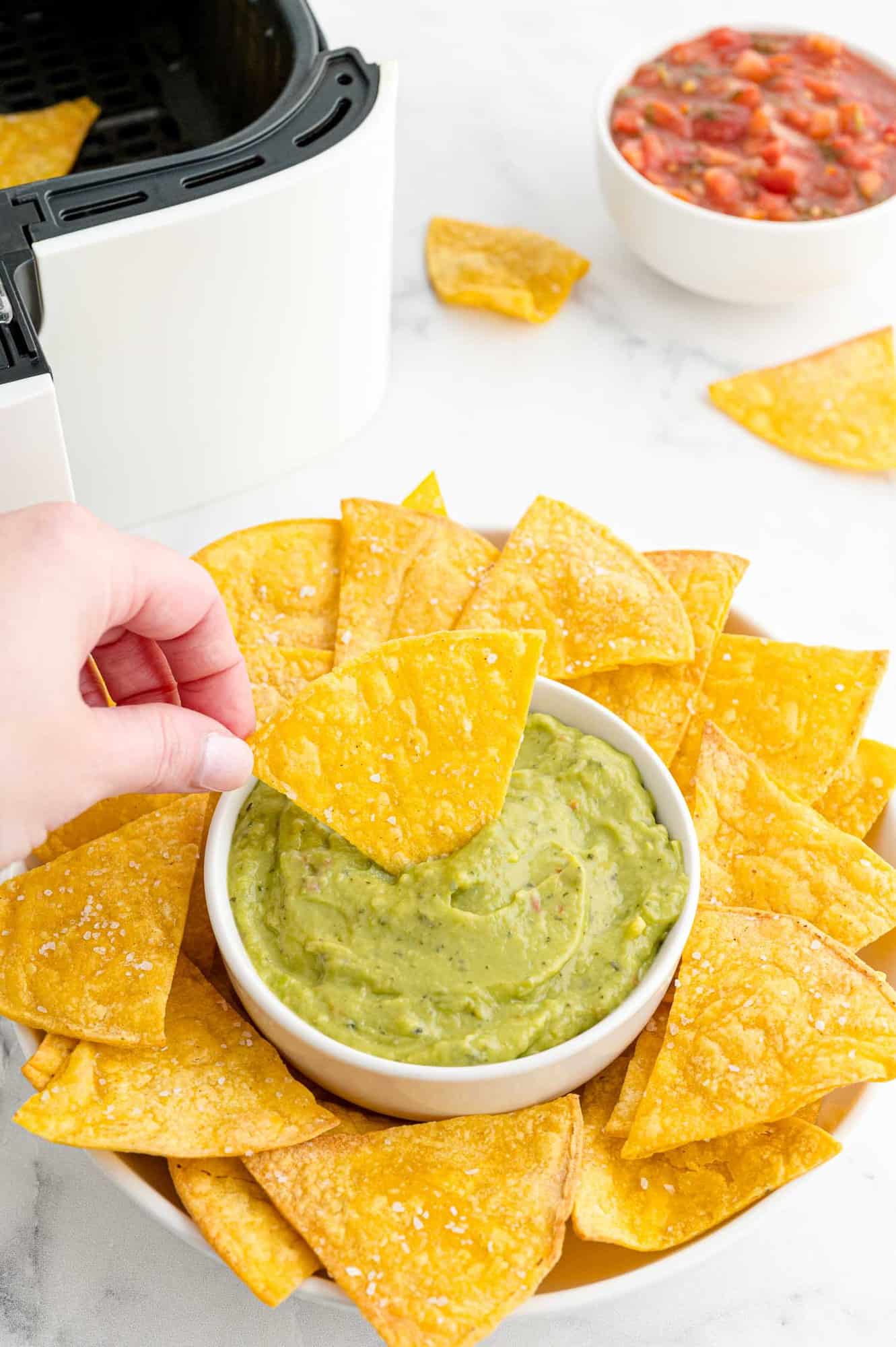 Chip being dipped in guacamole. 