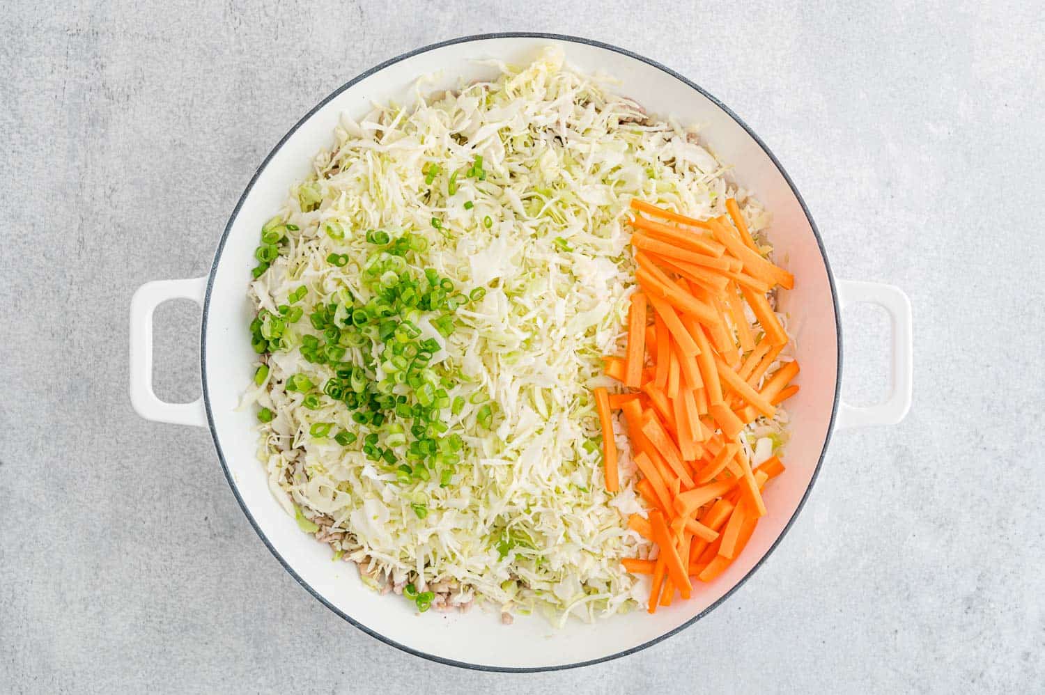 Fresh, shredded vegetables added to pan.