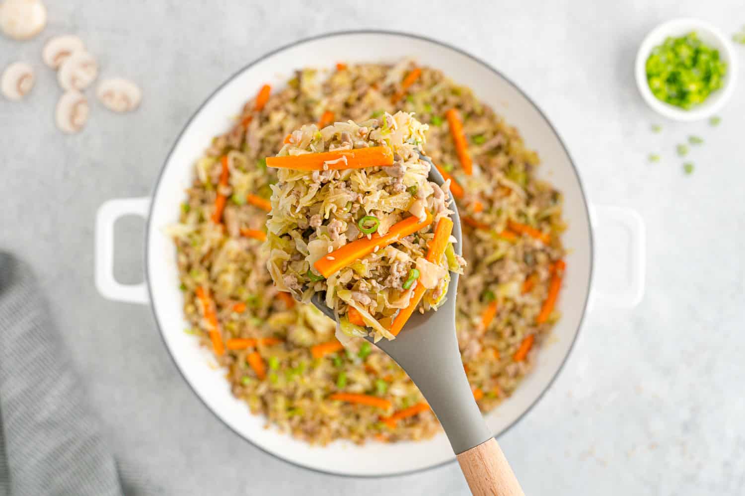 Egg roll mixture being scooped out of pan.