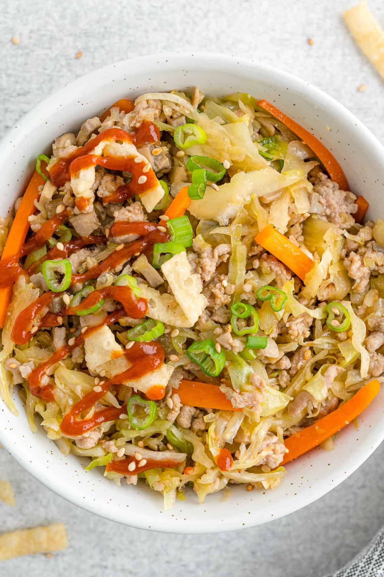 Close up of garnished egg roll in a bowl dish.