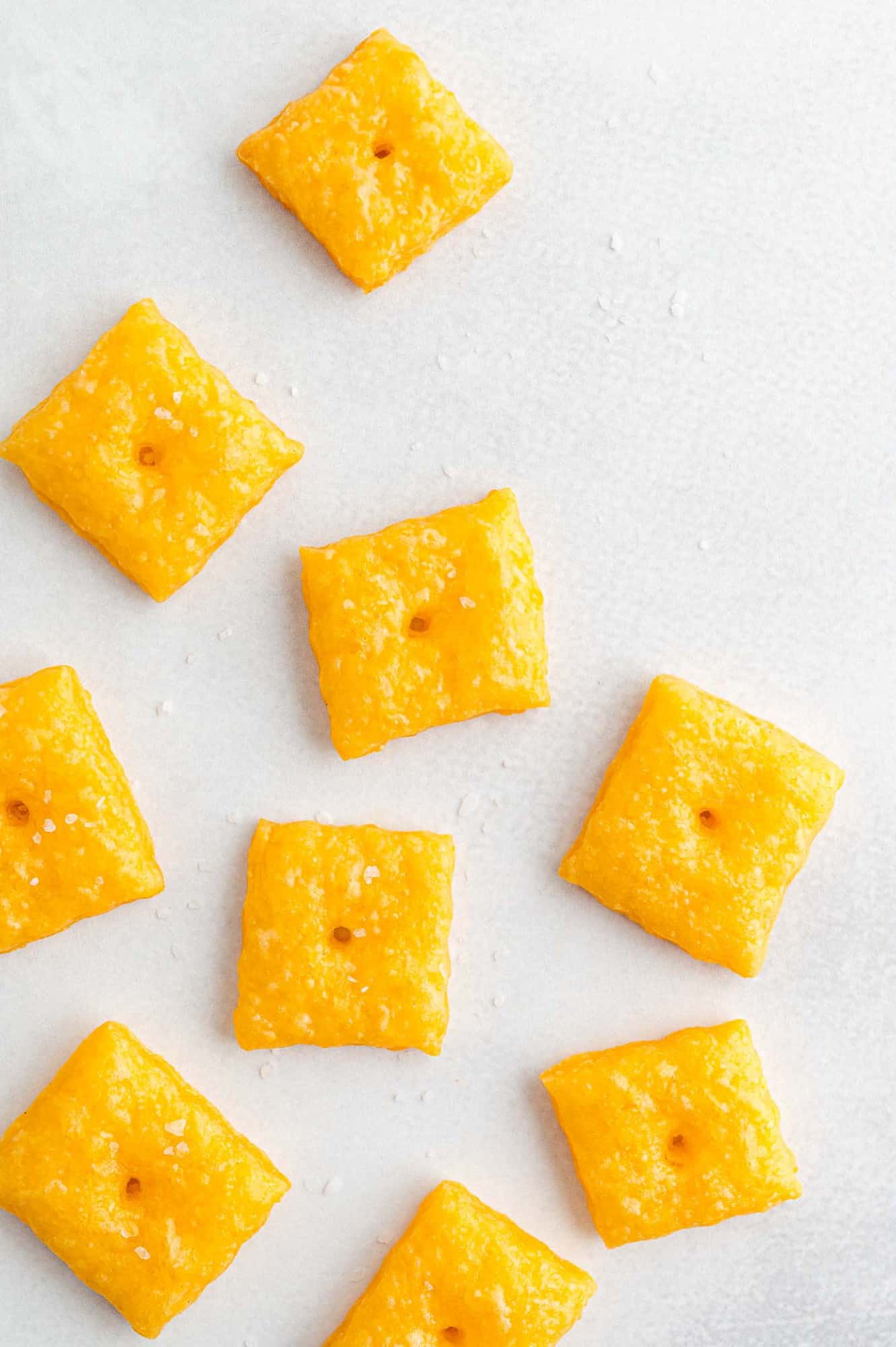 Cheez-its laid out on a white surface.