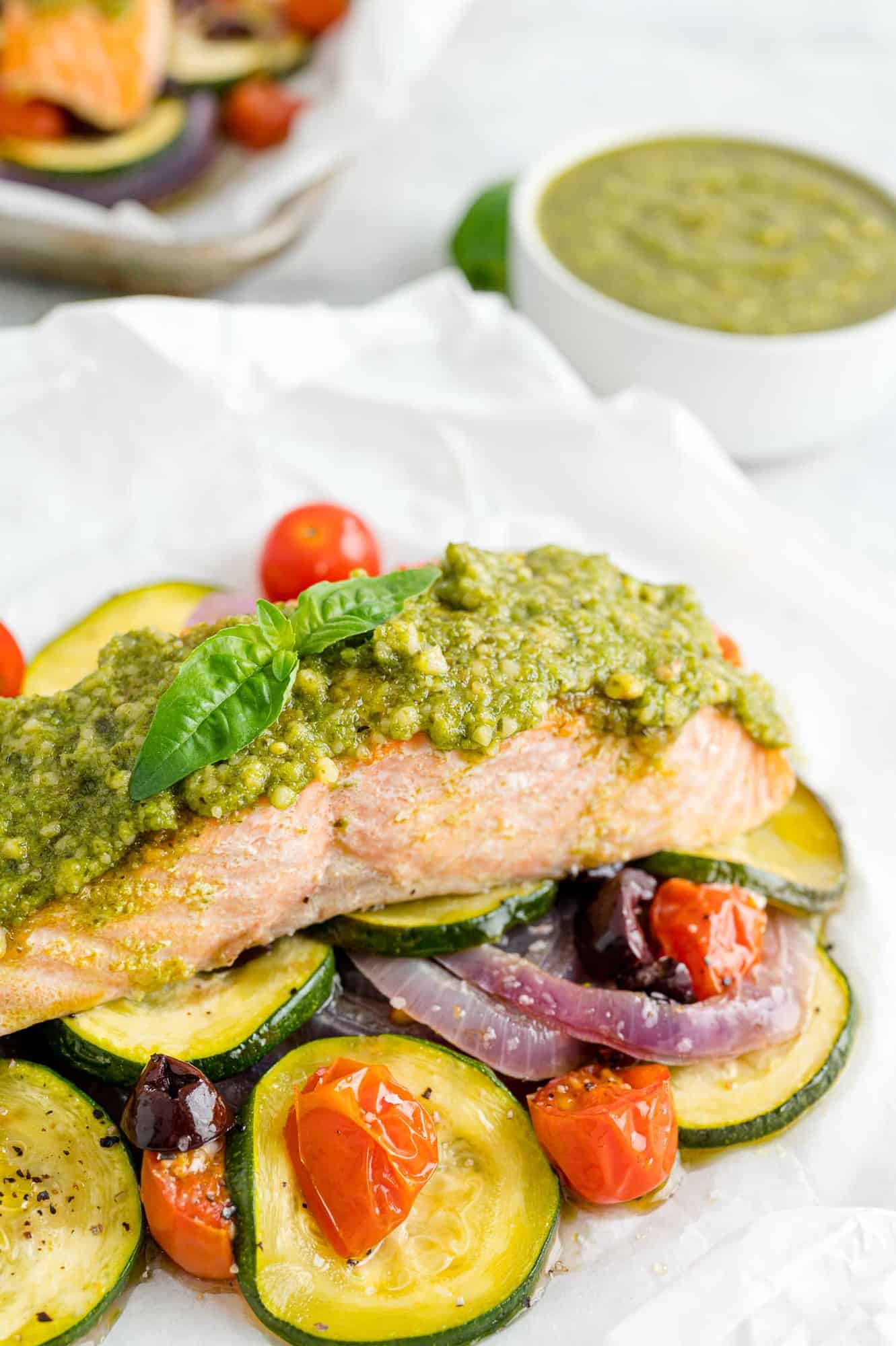 Pesto salmon with vegetables in parchment paper.