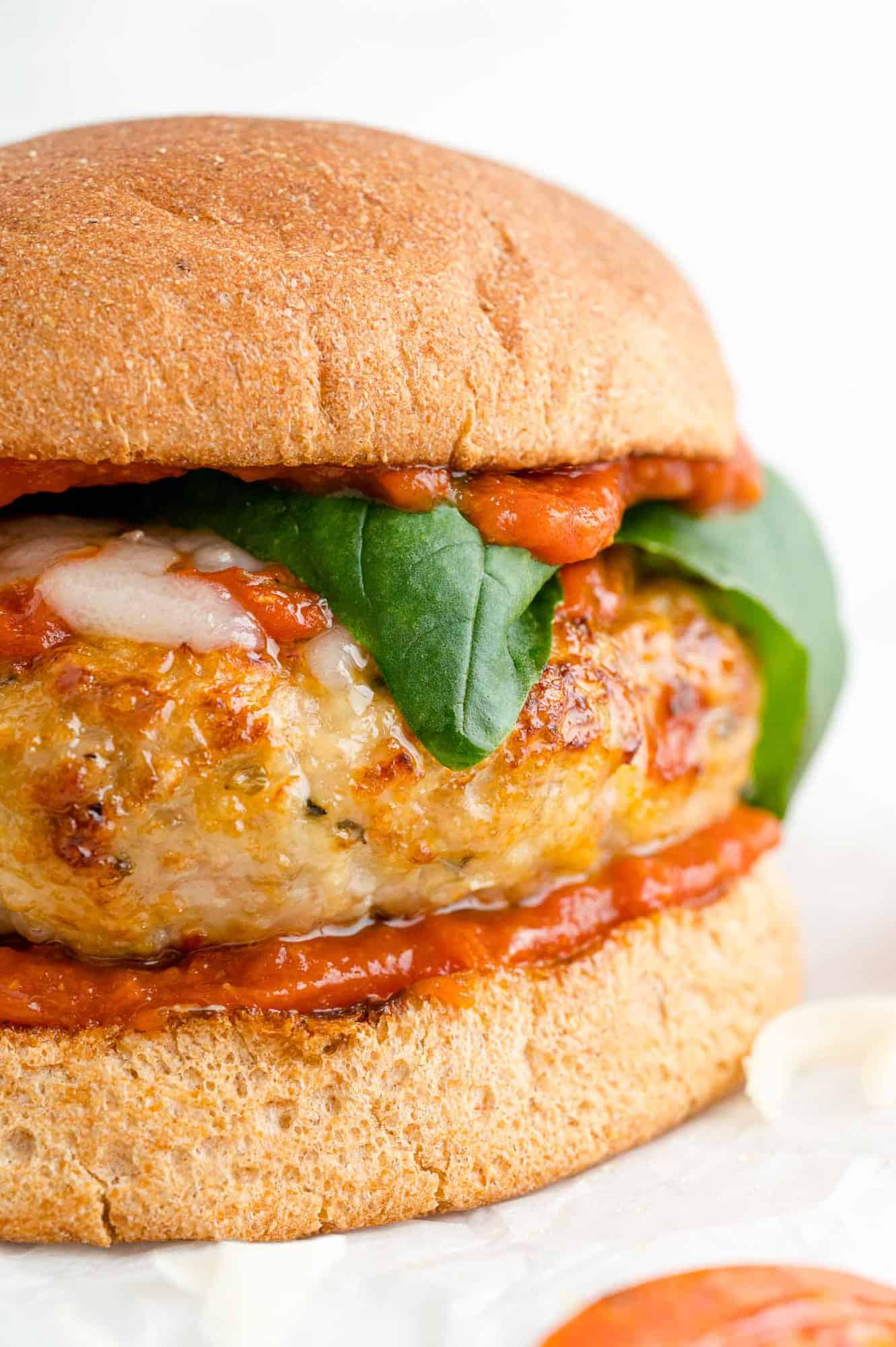 Pizza turkey burger on whole wheat bun with basil, marinara, and mozzarellal