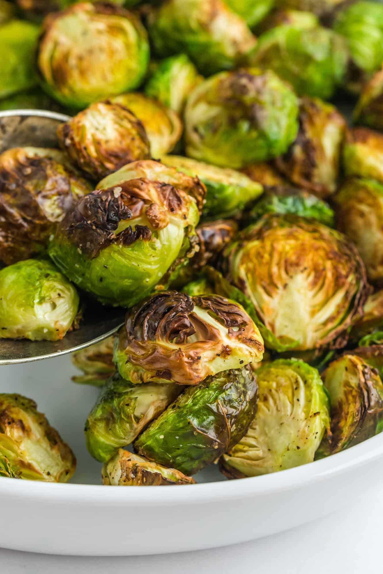 Air fryer Brussels sprouts in a white serving dish.