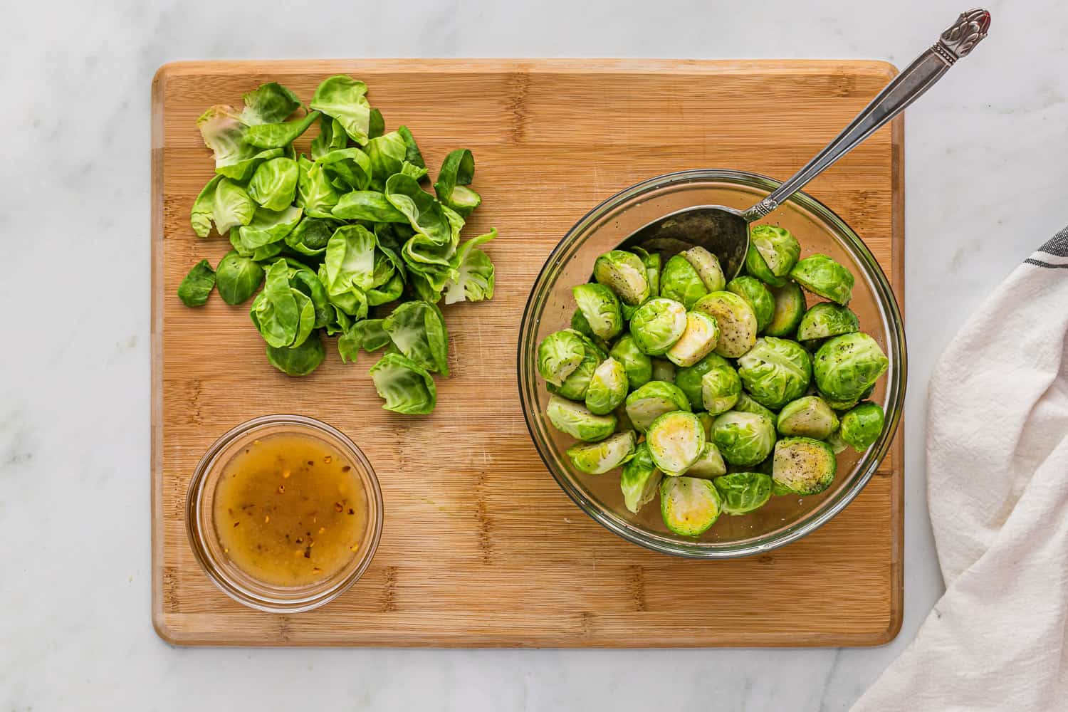 Brussels sprouts being mixed with oil and seasonings.