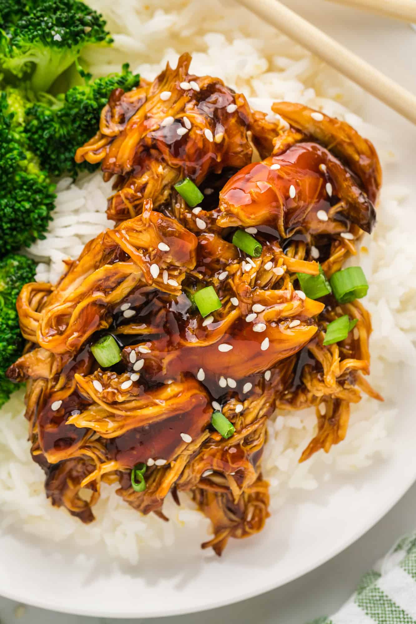 Boneless skinless chicken breasts and homemade teriyaki sauce served over rice or quinoa make this crock pot teriyaki chicken a perfect weeknight meal. Close up of teriyaki chicken on rice.