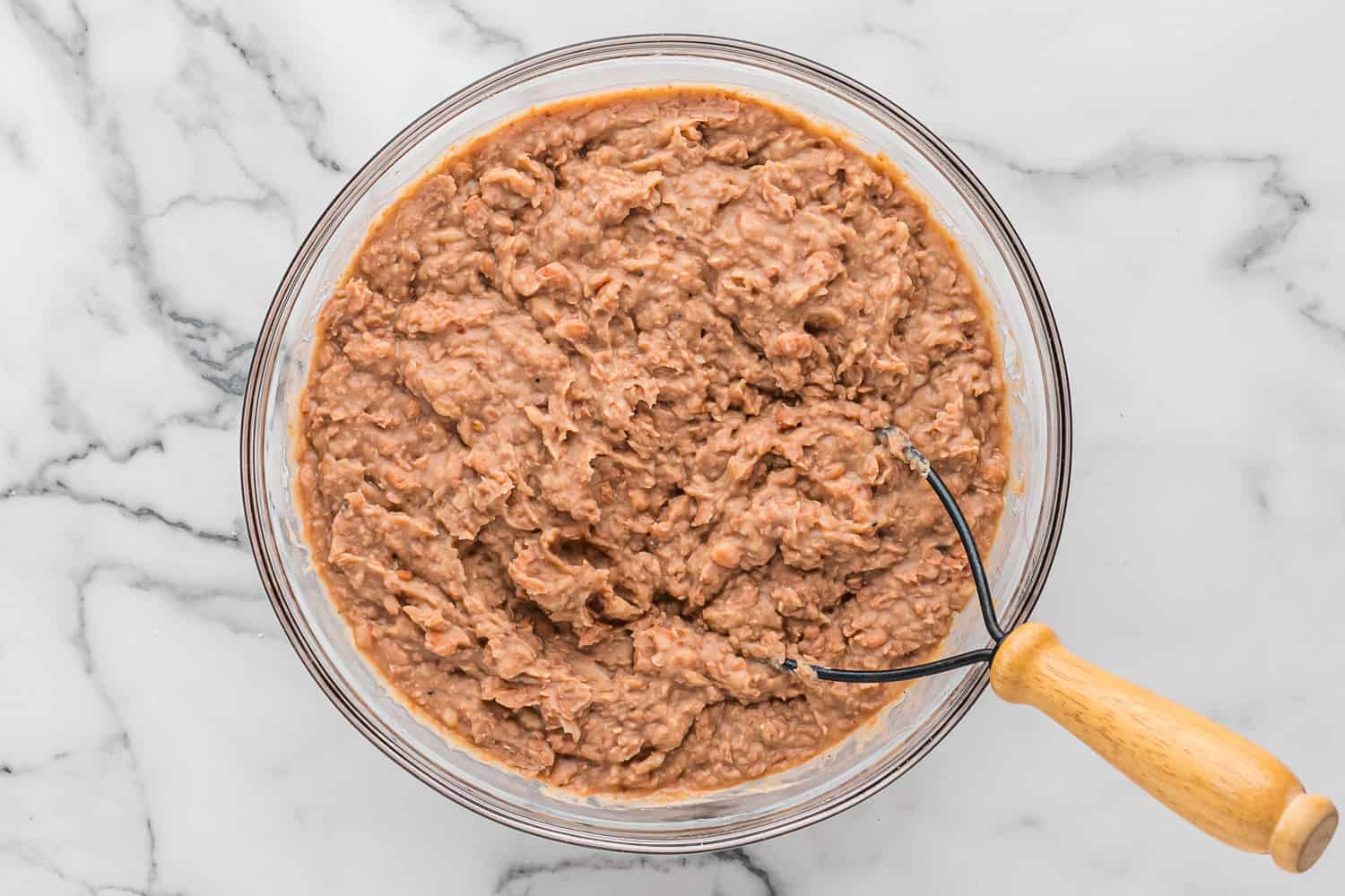 Beans mashed with a potato masher.