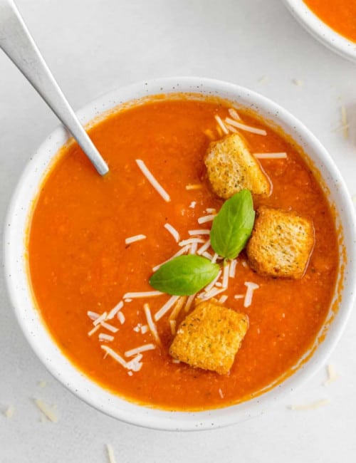 Roasted tomato soup in white bowl.