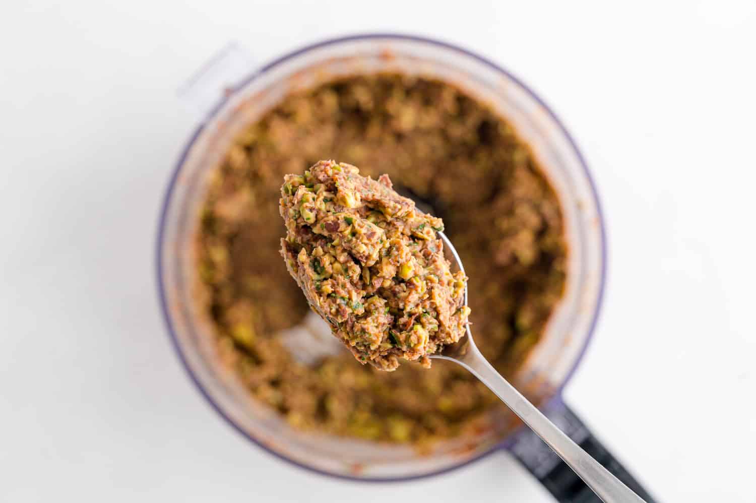 Black bean dip being scooped out of food processor.