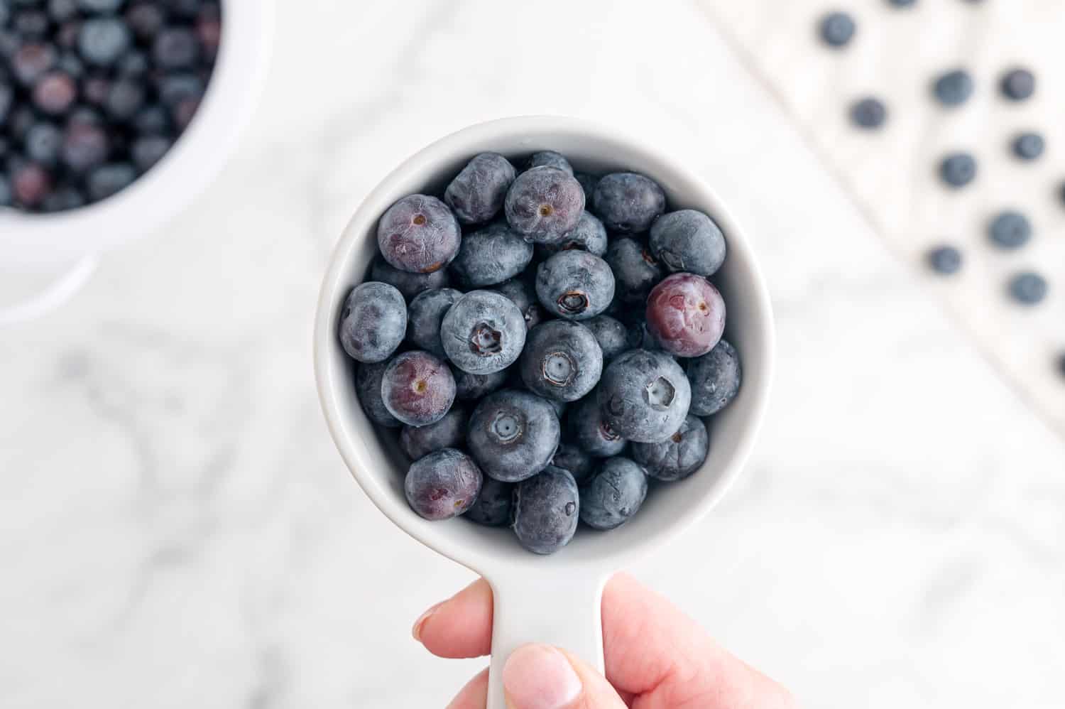 Blueberries in a measuring cup.