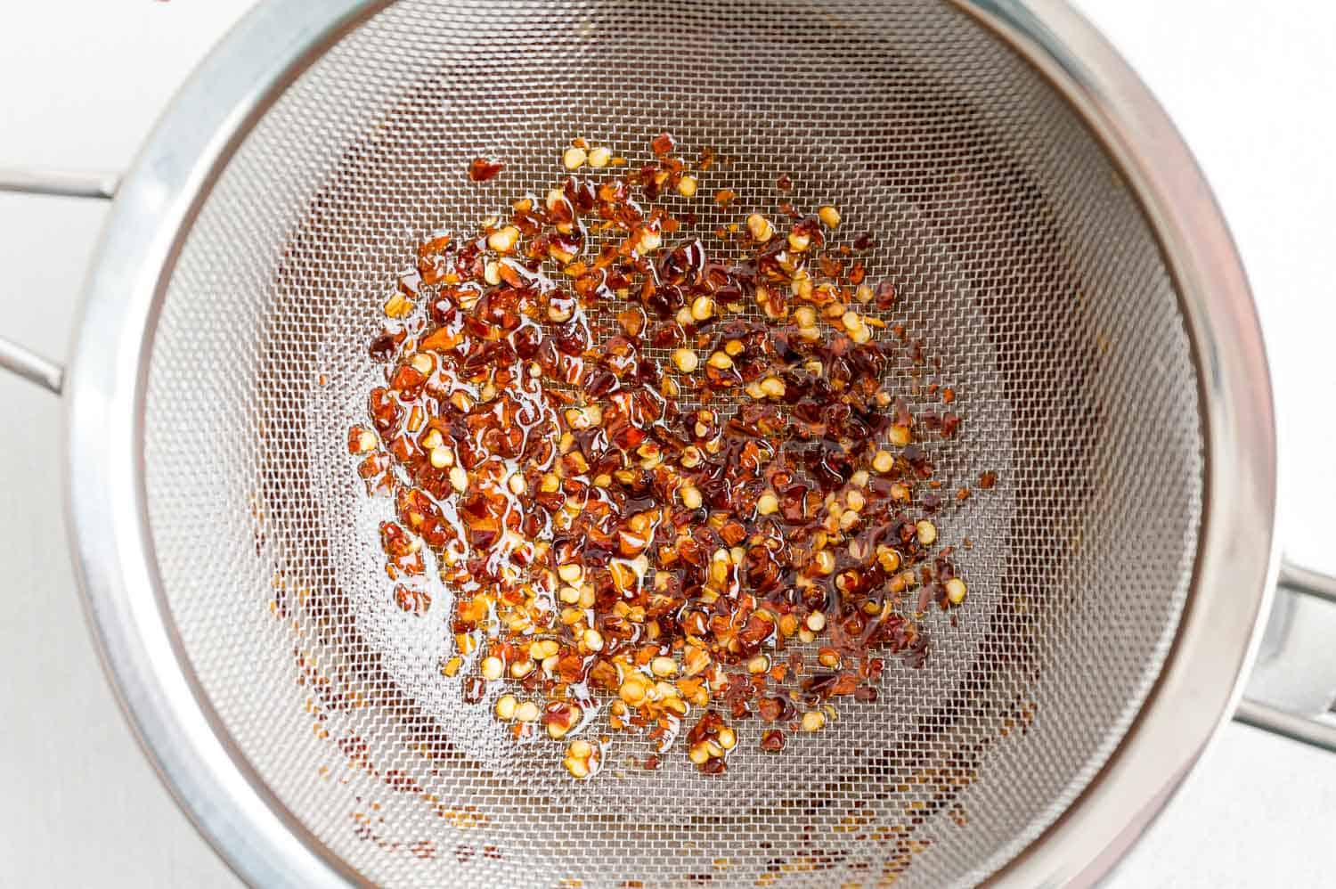 Red pepper flakes in a strainer.