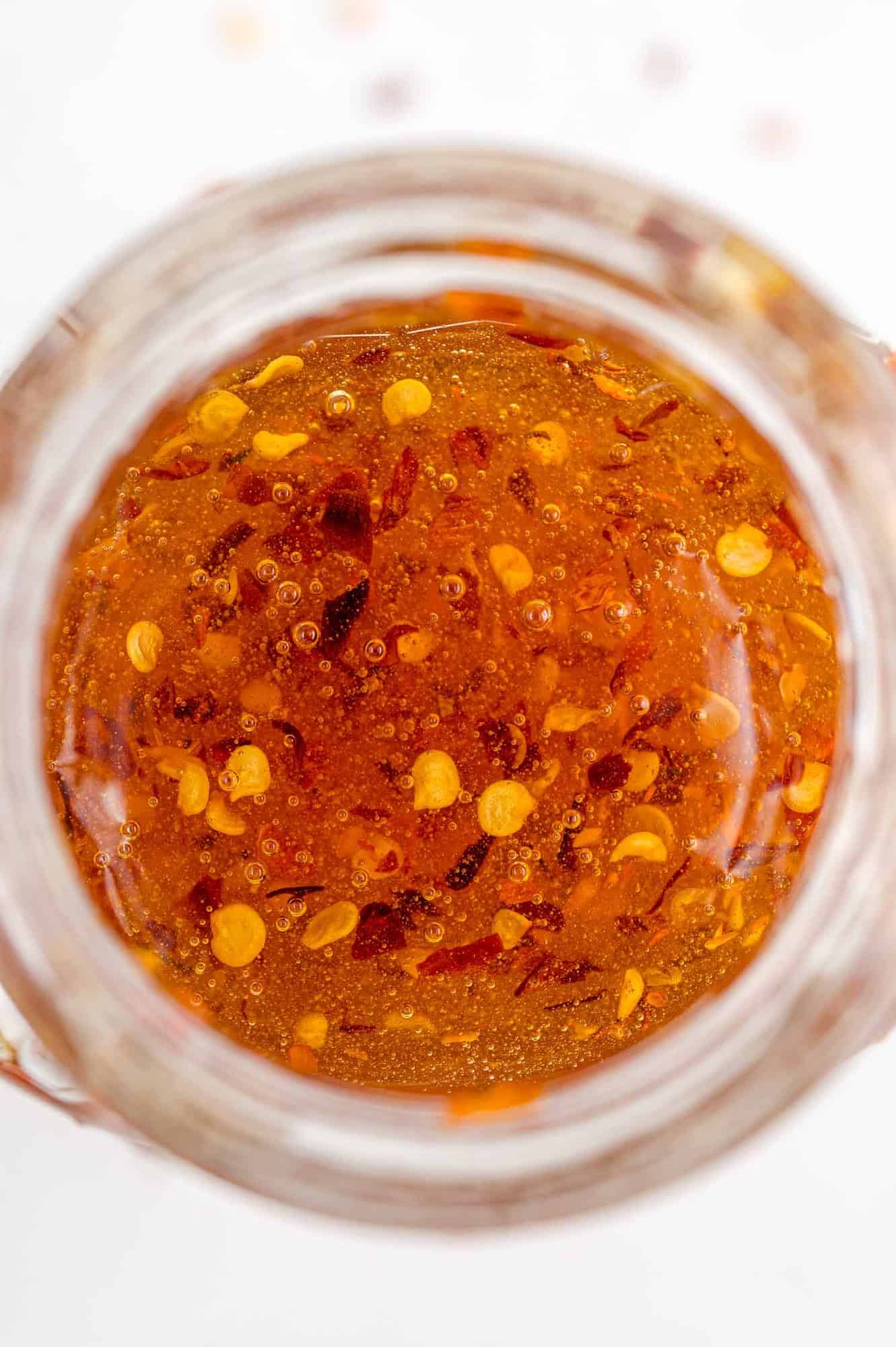Overhead view of hot honey in a clear glass jar.