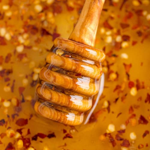 Close up of hot honey with a honey dipper.