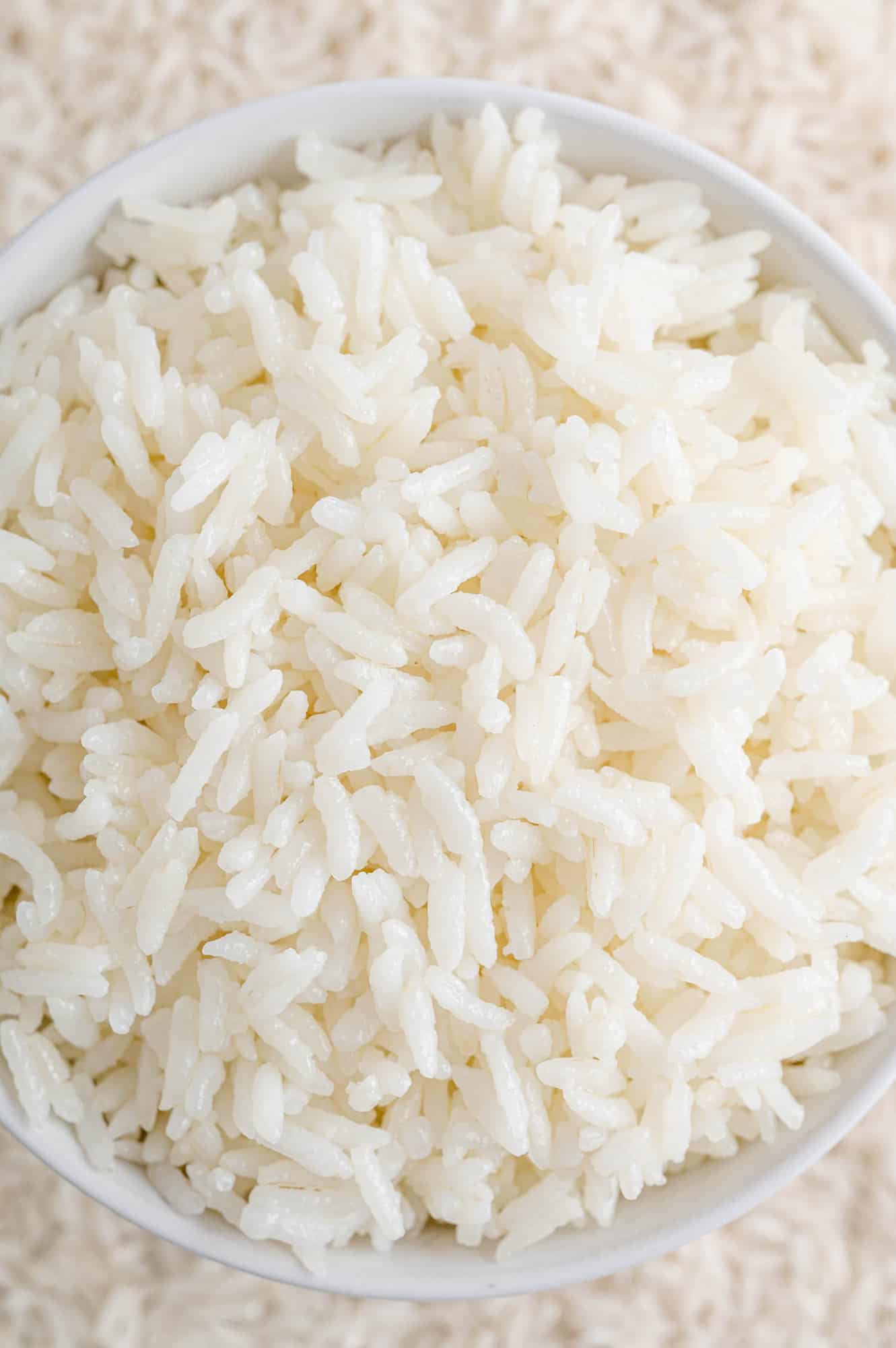 Close up of cooked white rice in a white bowl.