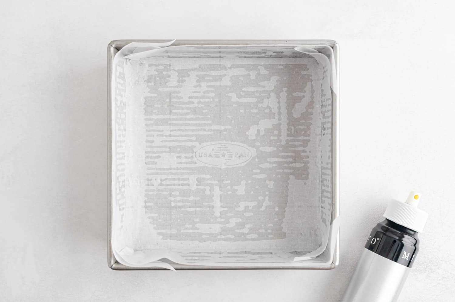 Square baking dish lined with parchment paper.