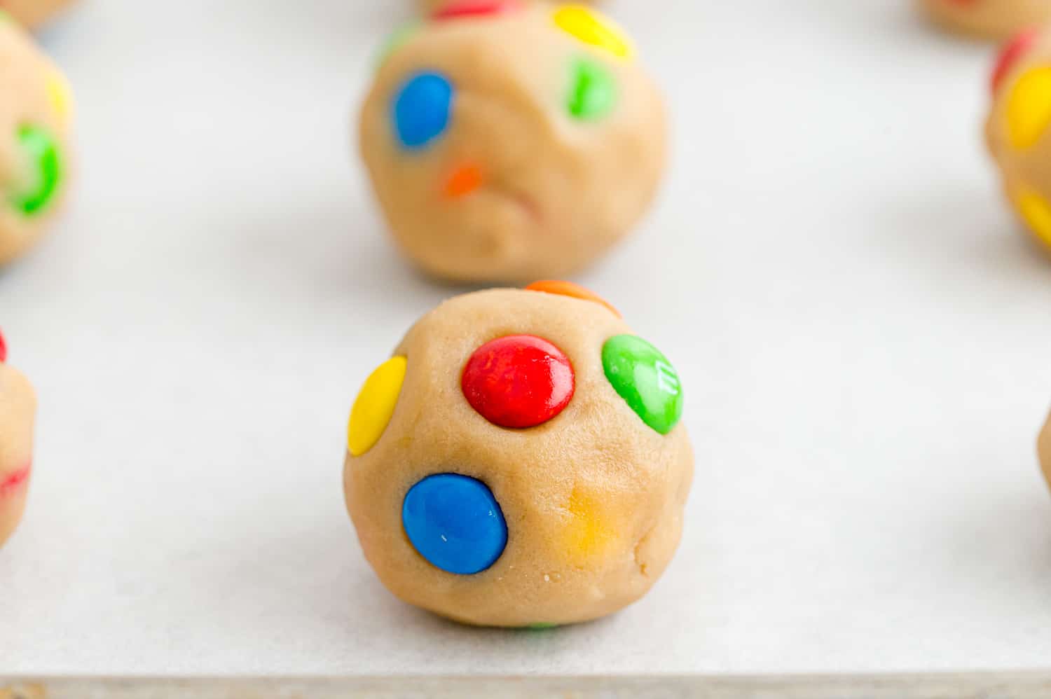 Unbaked cookie on lined baking sheet.