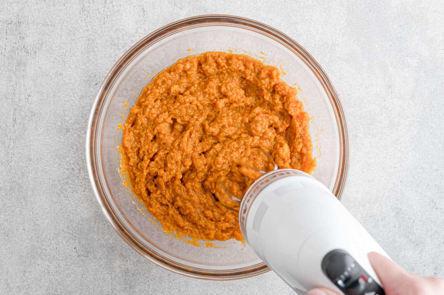 Sweet potatoes being mixed with a hand mixer.