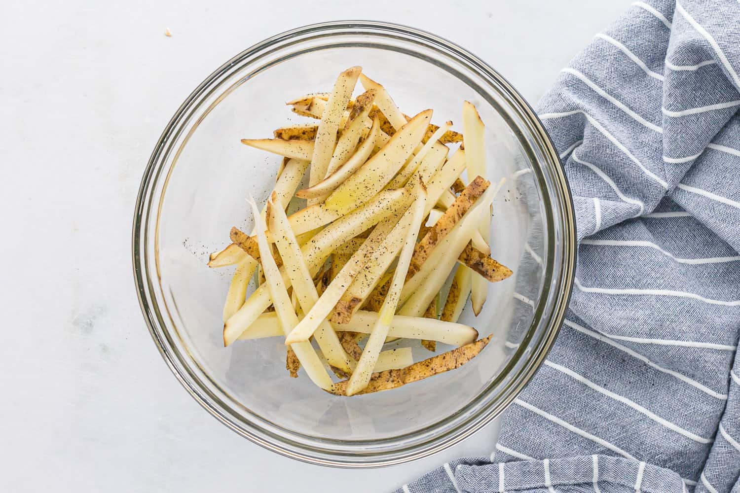 Uncooked fries with seasoning.