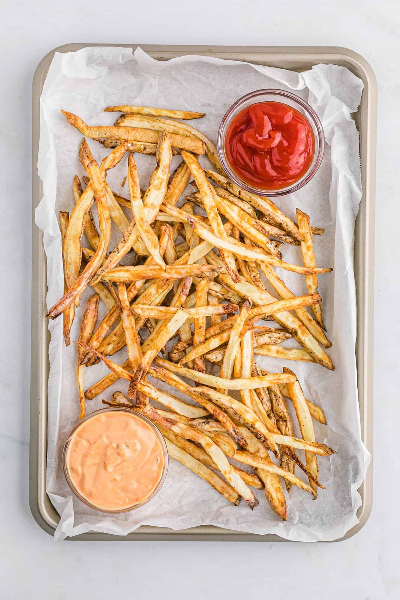 Overhead view of air fryer french fries with two dipping sauces.