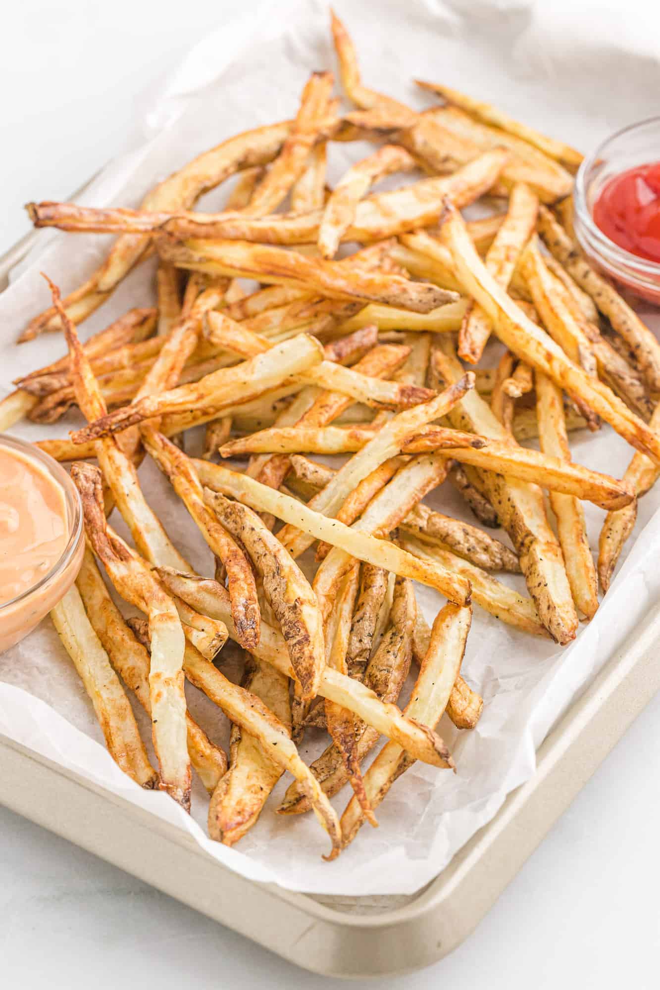 Fries on a lined baking sheet.