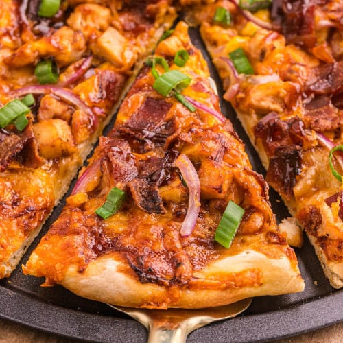 Slice of bbq chicken pizza being removed from pan.