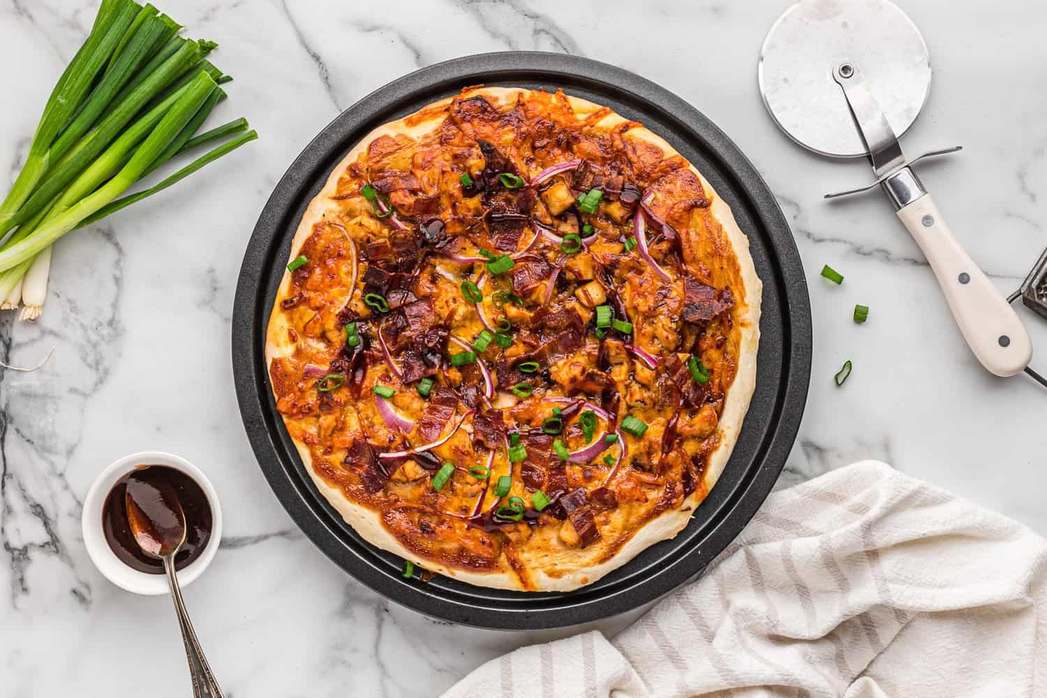 Cooked pizza topped with green onions.