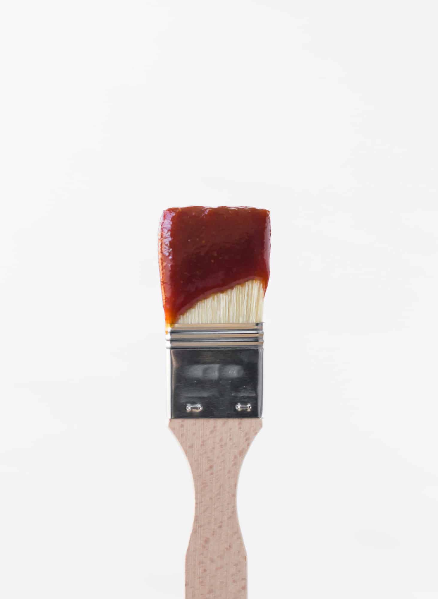 BBQ sauce on a wooden handled brush.