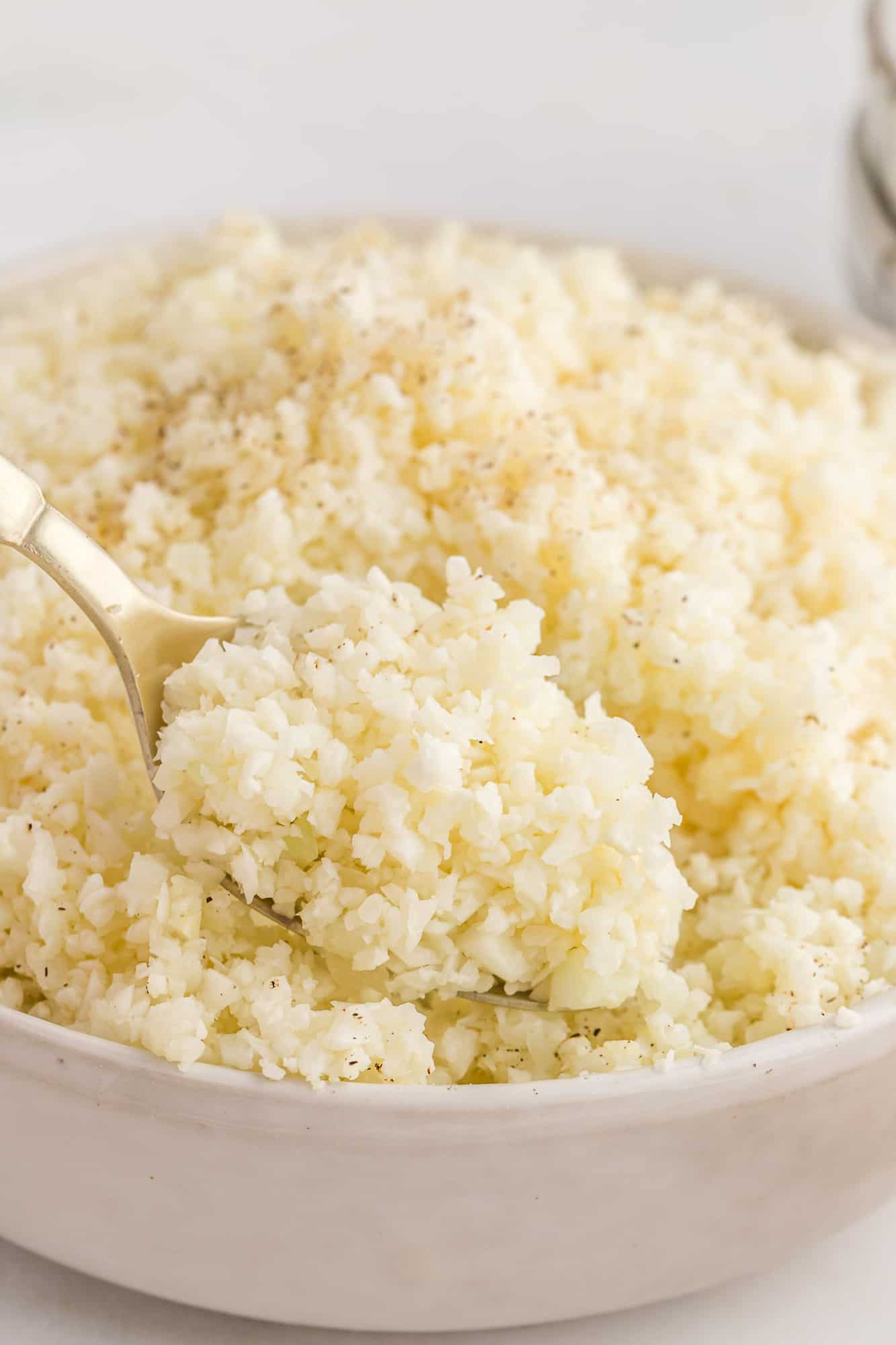 Riced cauliflower on a spoon to show texture.