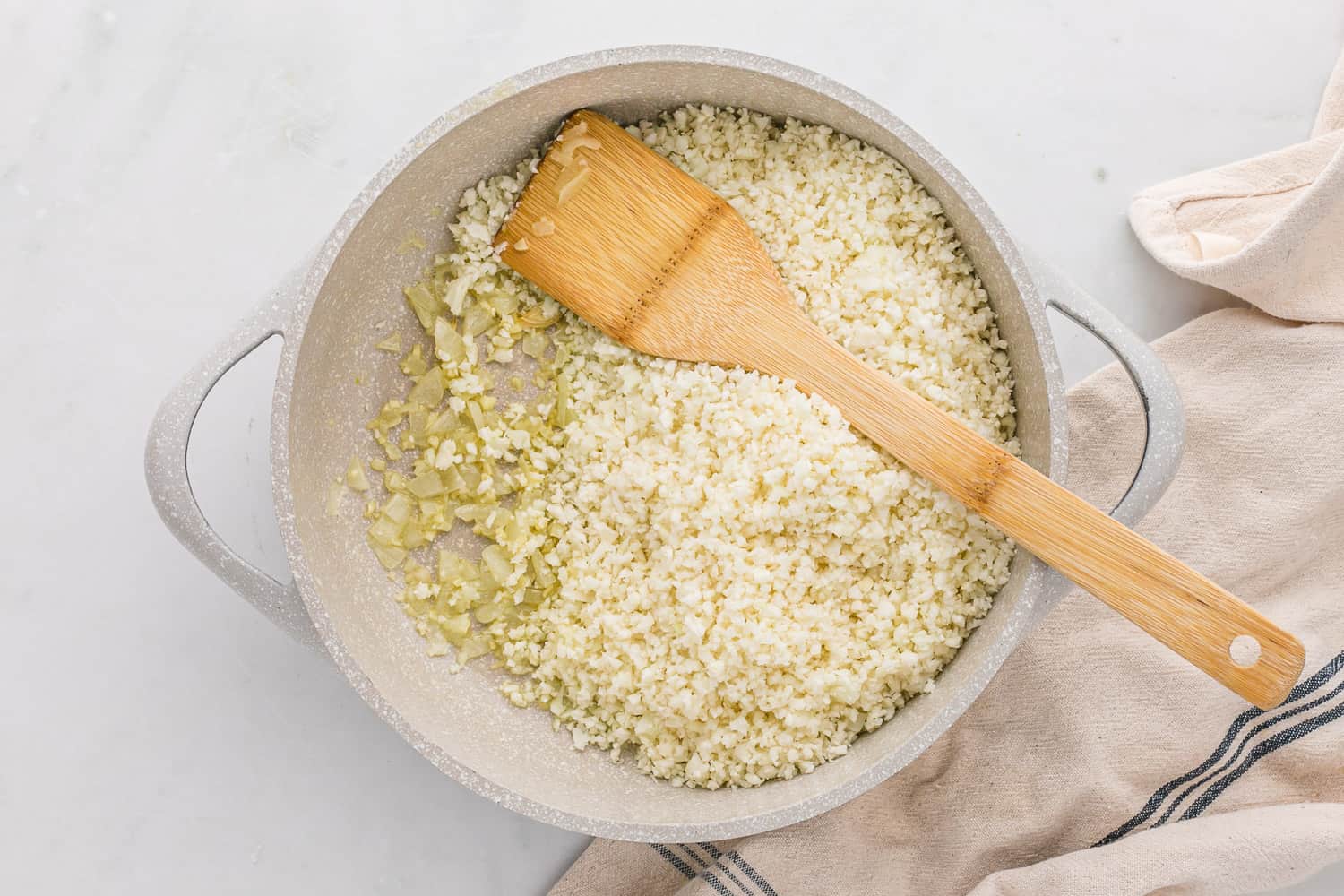 Riced cauliflower in a skillet, not yet cooked.