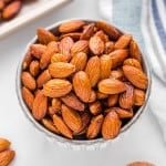 Olive oil roasted almonds in a small round bowl.