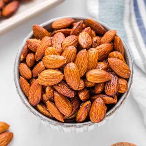 Olive oil roasted almonds in a small round bowl.