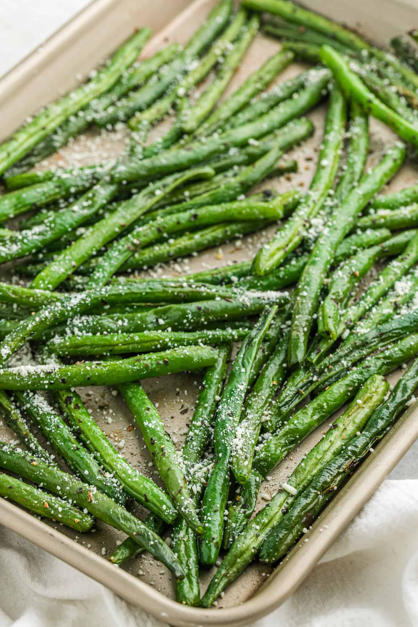 Roasted green beans with parmesan on a sheet pan.