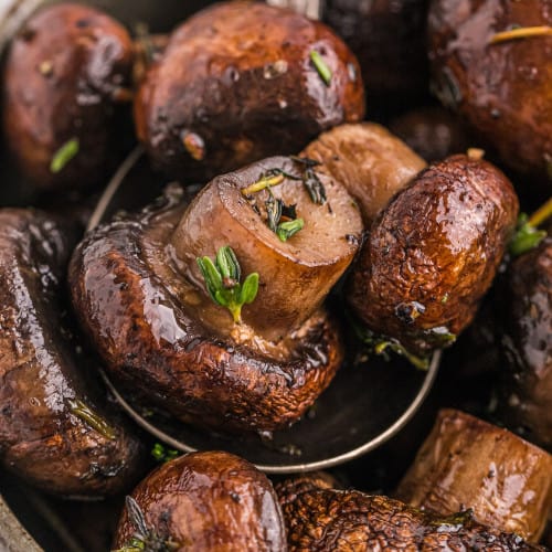 Close up of a perfectly roasted mushroom with fresh thyme.