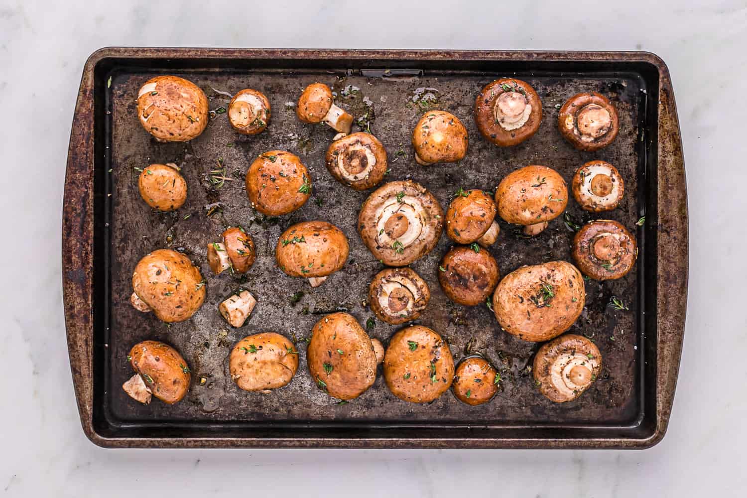 Uncooked mushrooms on a baking sheet.