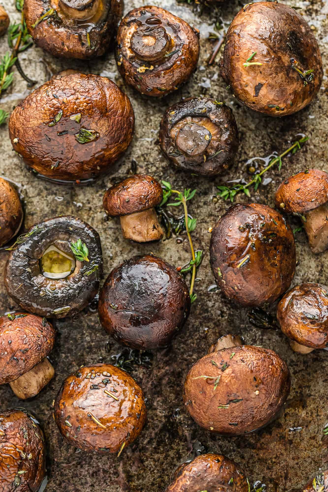 Roasted mushrooms on sheet pan garnished with fresh thyme.