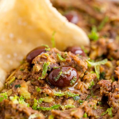 Black bean dip with a chip being dipped in it.